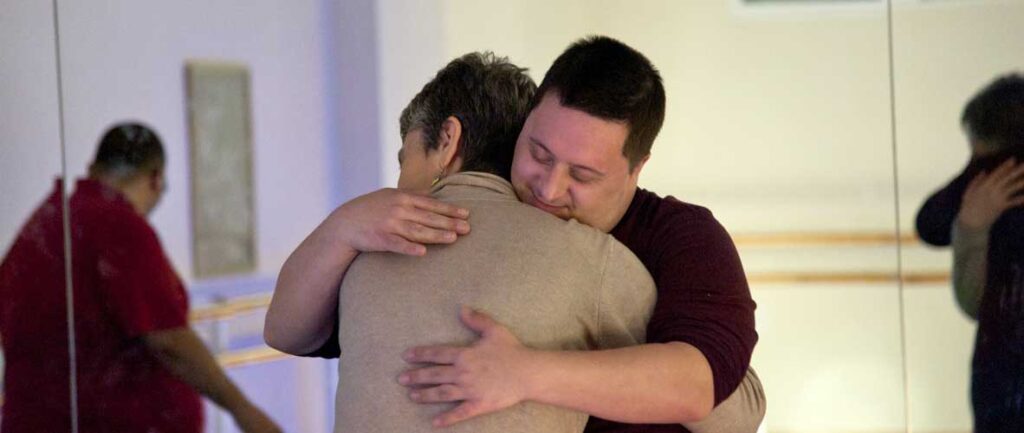Dos participantes de una residencia artística fundidos en un abrazo