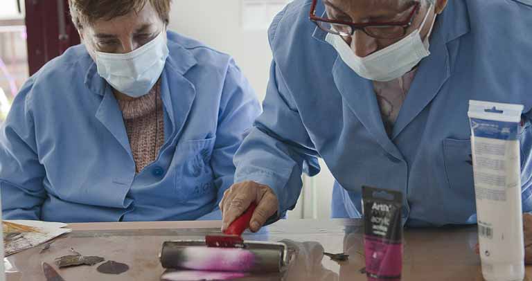 Imagen de recurso. Dos mujeres mayores trabajando con pintura en un taller