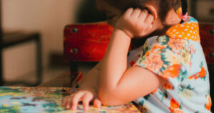 Una niña leyendo en un aula.